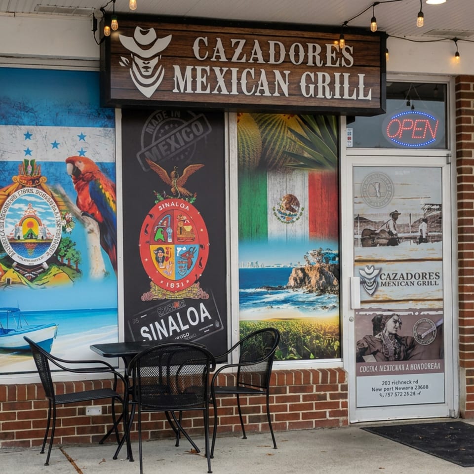 Cazadores Mexican Grill storefront with colorful Mexican murals, illuminated open sign, outdoor tables, and brick facade.
